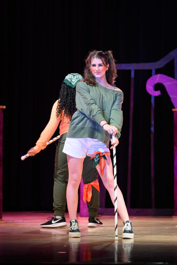 Theater character on stage with a cane